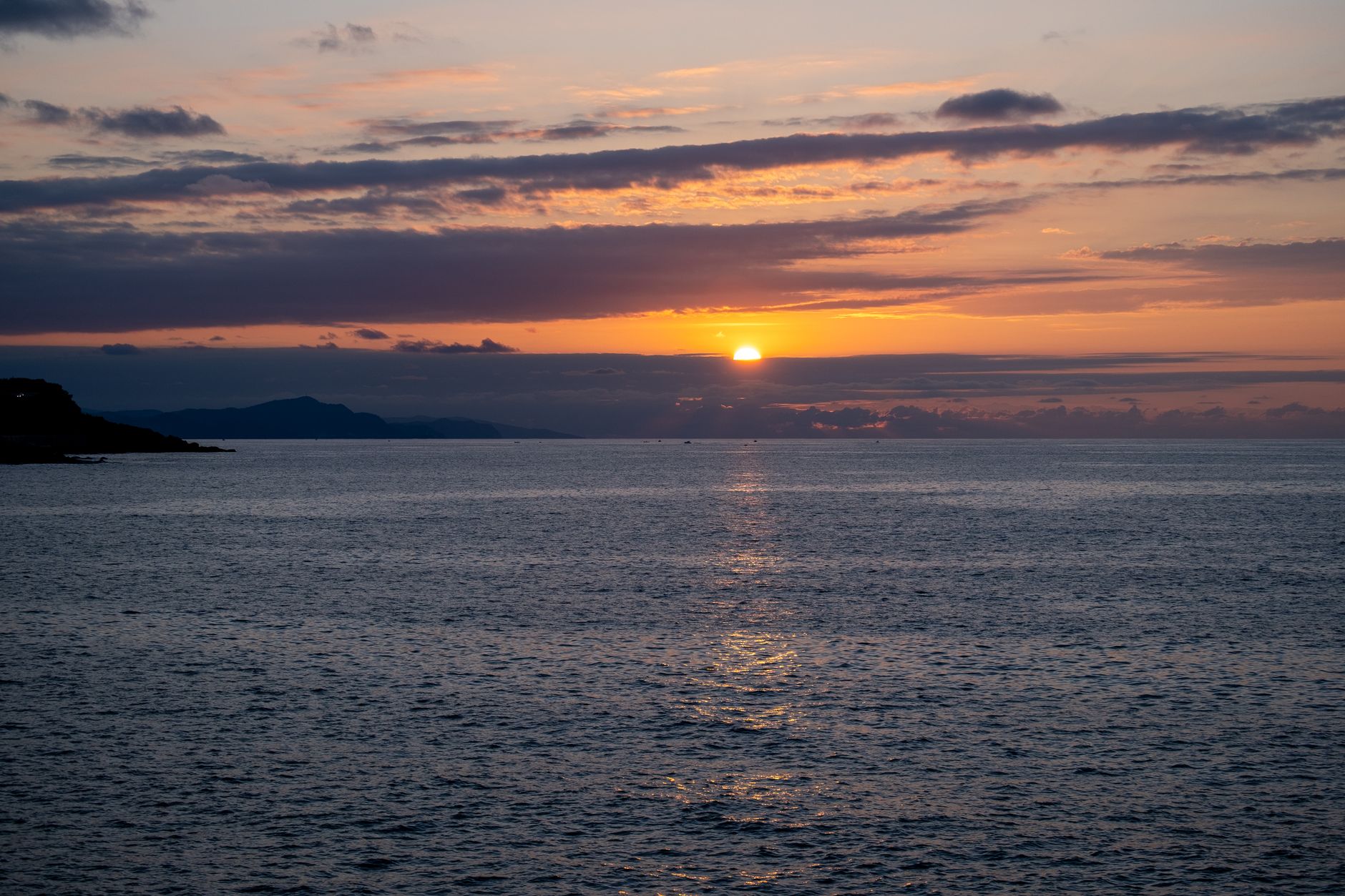 橘湾に沈む夕日と小浜温泉の湯けむりイメージ